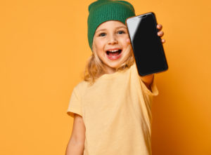 Happy child holding up cell phone